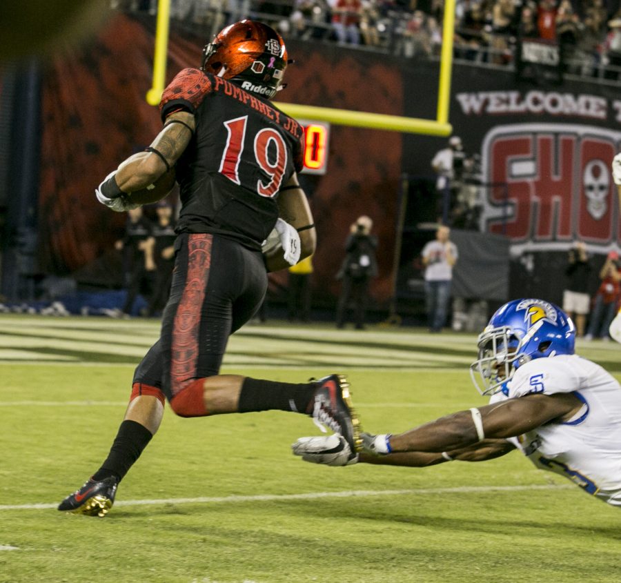 Senior running back Donnel Pumphrey (19) flies by a diving SJSU defender, on his way to a rushing touchdown.