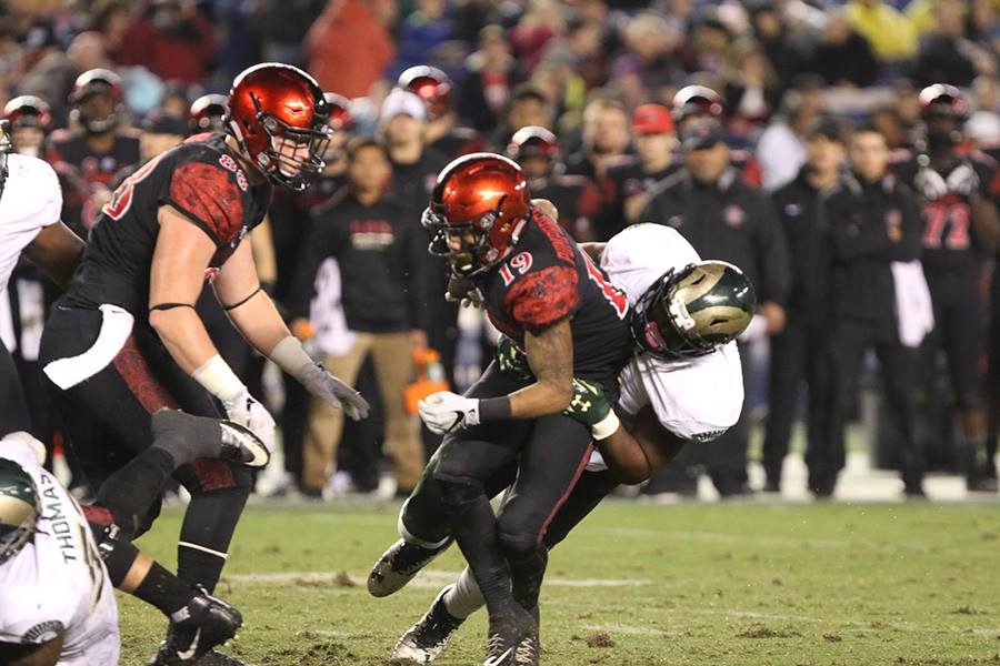 Senior running back Donnel Pumphrey (19) is tackled in the backfield by a Colorado State defender. 