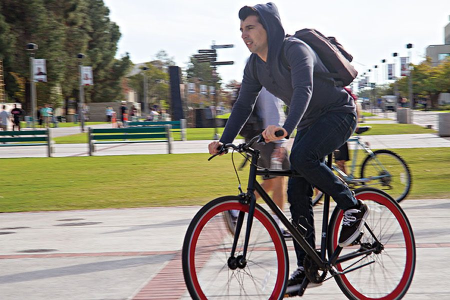 An+SDSU+student+pedals+across+campus