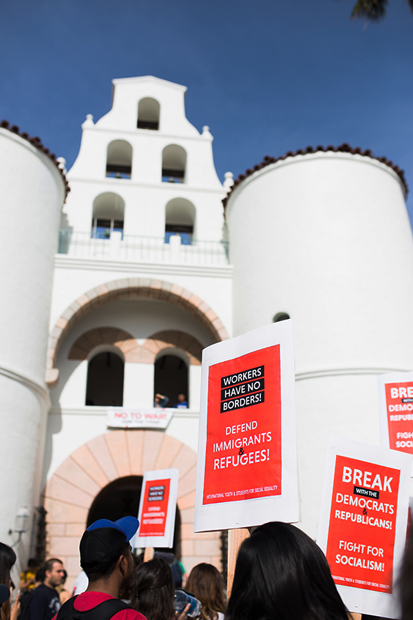 Protesters hold signs advocating for the International Youth and Students for Social Equality during a February protest in front of Hepner Hall.