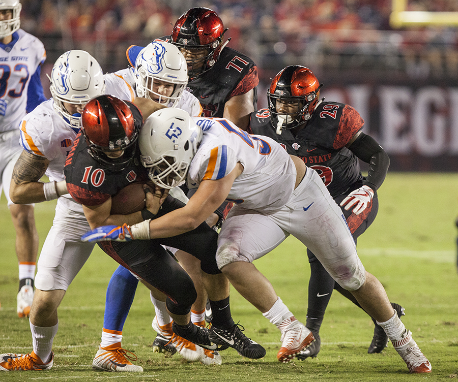 A herd of Bronco defenders converge on redshirt junior quarterback Chirstian Chapman during SDSU’s 14-31 loss to Boise Sttae on Oct. 14. Chapman was sacked four times by the Broncos.