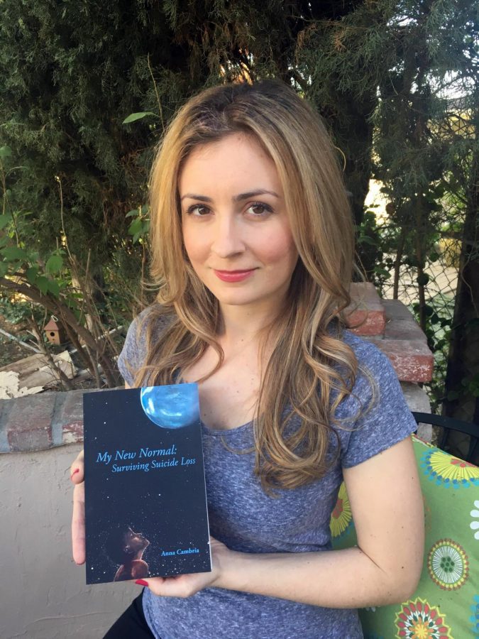 Anna Cambria poses with her self-published book My New Normal: Surviving Suicide Loss.