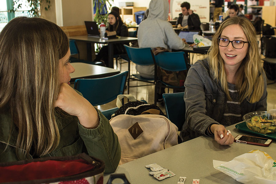Amanda Sisco, estudiante de maestría de trabajo social, platica con estudiante Kashina Rusko mientras come su almuerzo.
