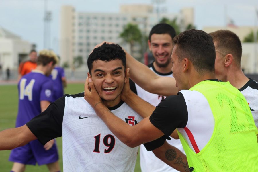 Senior forward Damian German is mobbed by teammates after assisting on a goal during the Aztecs 2-1 loss to Washington on Oct. 7 at the SDSU Sports Deck. 
