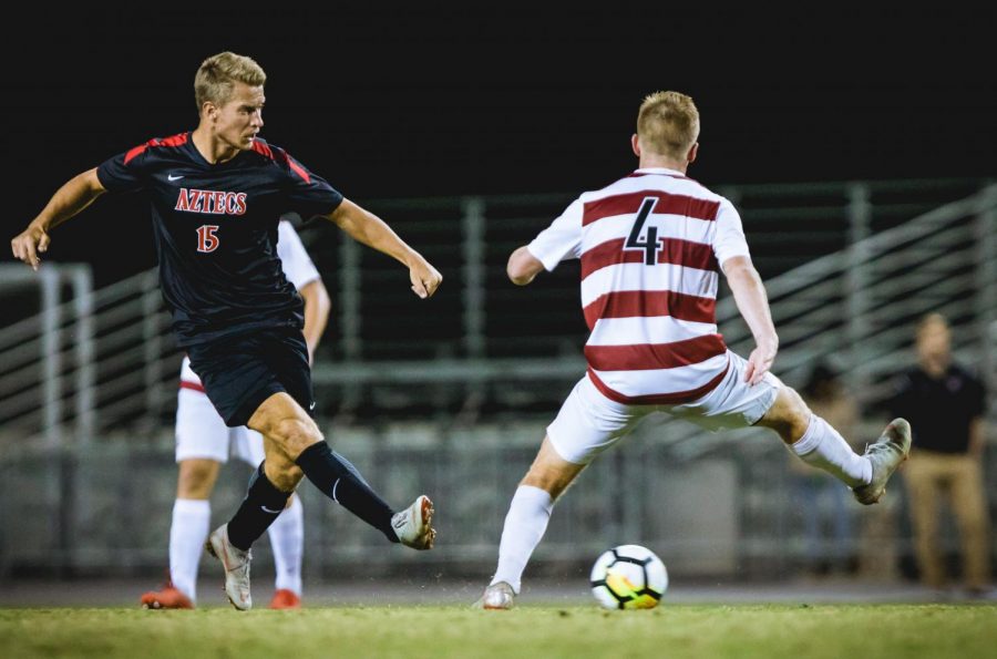 Junior midfielder Hampus Bergdahl attempts to kick the ball around a Stanford defender during the Aztecs 2-0 loss to the Cardinal on Nov. 4 at the SDSU Sports Deck.