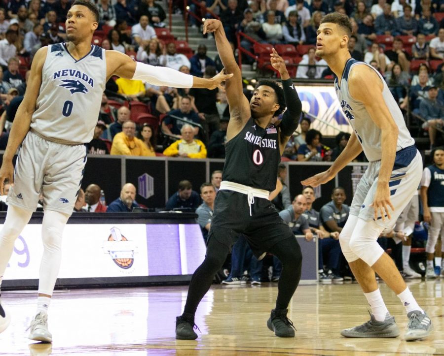 Senior guard Devin Watson launches a 3-pointer over two Nevada defenders during the Aztecs 65-56 victory on March 16 at the Thomas and Mack Center in Las Vegas.