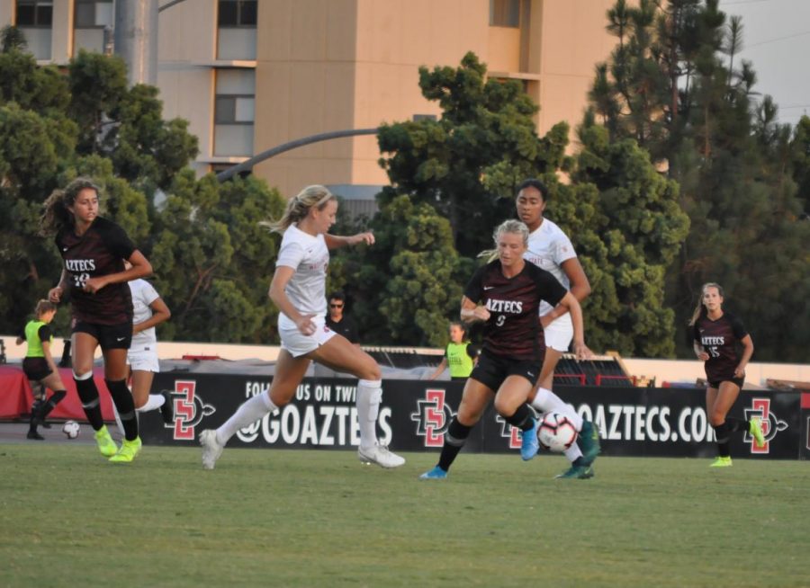 SDSU junior midfielder Chloe Frisch attempts to escape from Washington State defenders during the Aztecs exhibition on Aug. 16 at the SDSU Sports Deck.