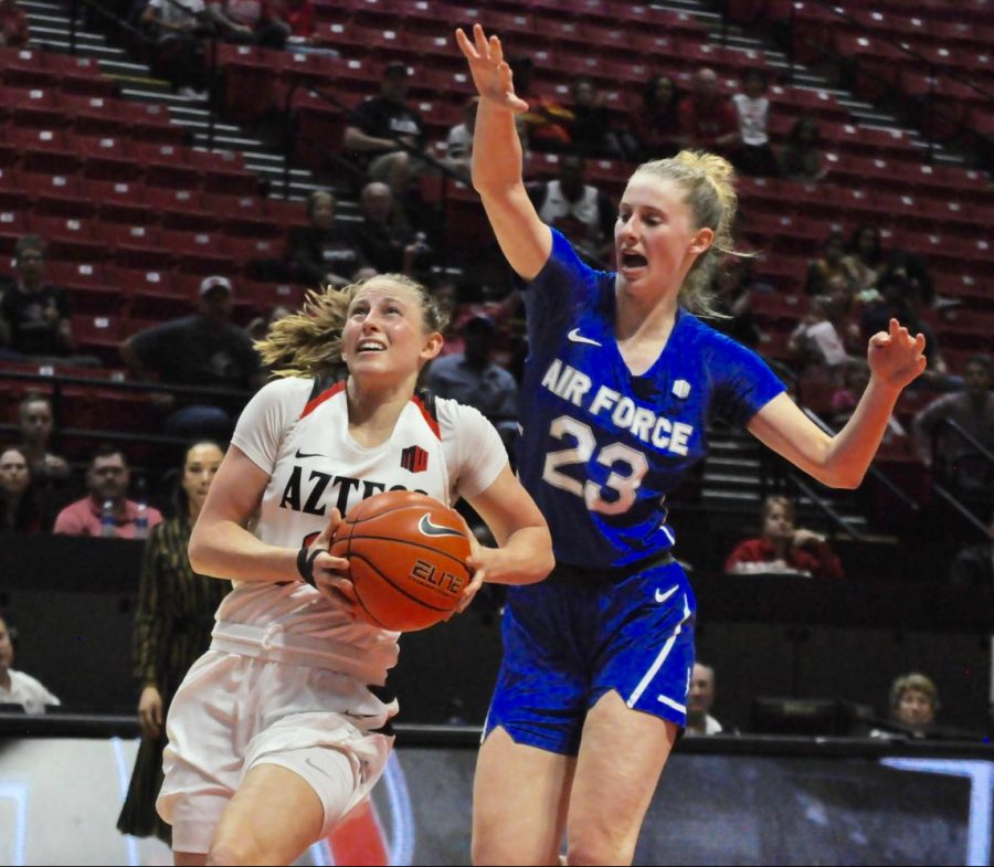 Senior guard Taylor Kalmer goes pass the Air Force defender for a layup. Kalmer has had 19 straight double-digit scoring games – the longest streak by an Aztec in the Mountain West era (since 1999).