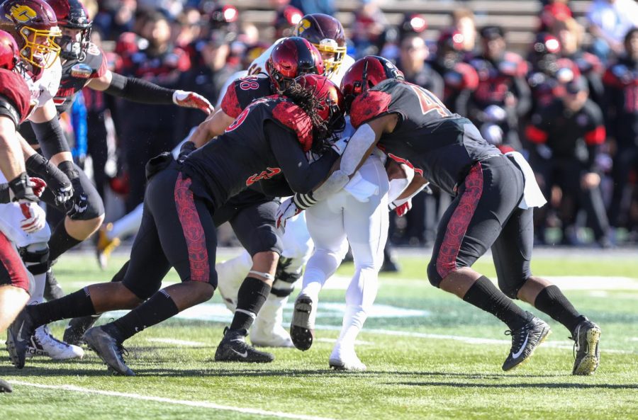 Then-junior safety Dwayne Johnson Jr., then-junior linebacker Andrew Aleki and then-senior linebacker Kyahva Tezino combine for a tackle against a Central Michigan ballcarrier during the Aztecs 48-11 win over the Chippewas in the New Mexico Bowl at Dreamstyle Stadium in Albuquerque, New Mexico.