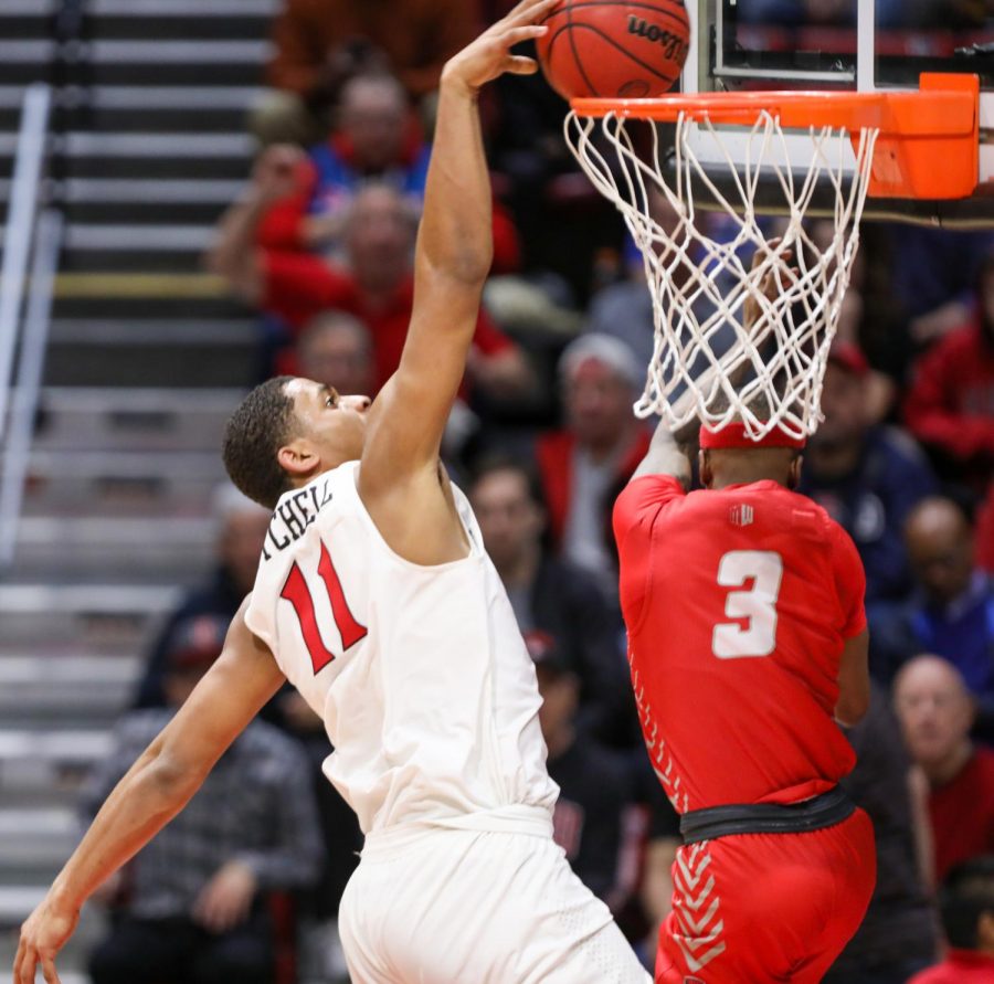 San Diego State mens basketball then-junior forward Matt Mitchell completes a dunk over a New Mexico defender during the Aztecs 82-59 win over the Lobos on Feb. 11, 2020 at Viejas Arena. With the win, the Aztecs became the 2020 Mountain West regular-season champions.