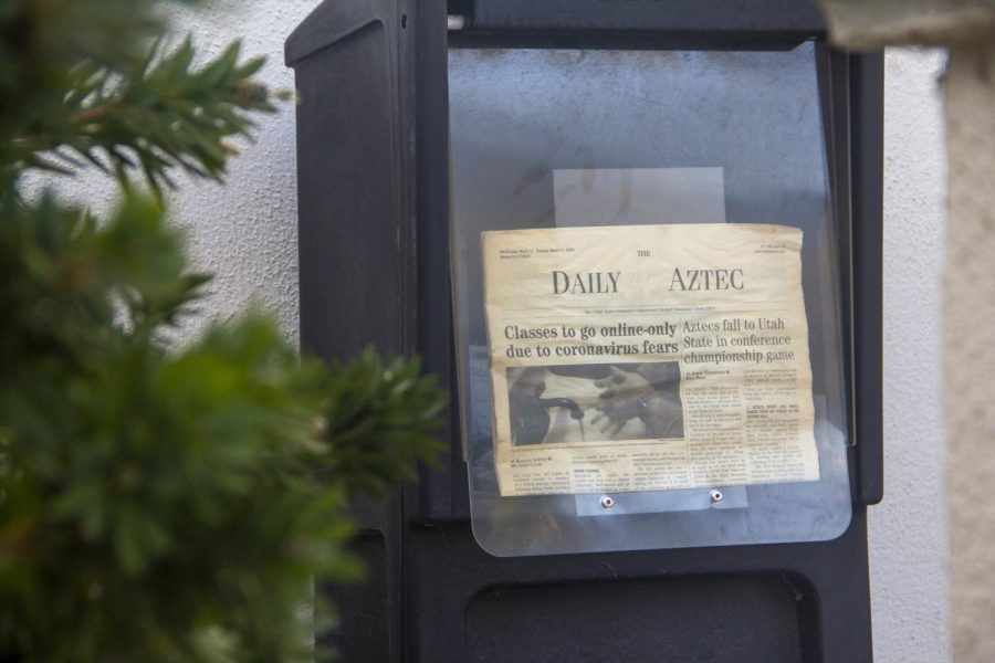 A newstand with an old, faded edition of The Daily Aztec print edition.