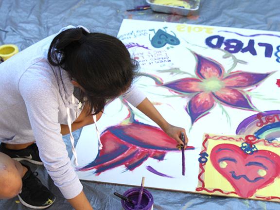 A student makes a poster for a Love Your Body Day event in 2013. File photo