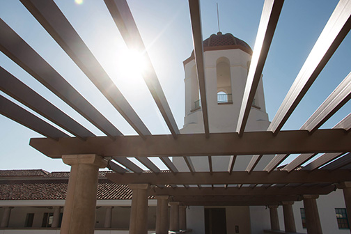 The sun shines through a natural shade covering of the Aztec student union.