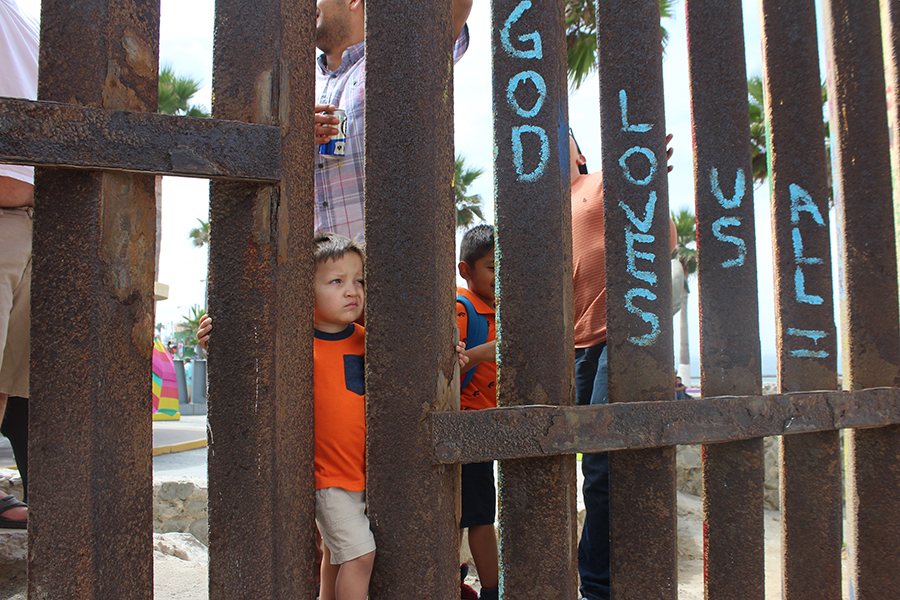 A+child+standing+in+Tijuana+peers+through+the+border+fence+at+Friendship+Park.