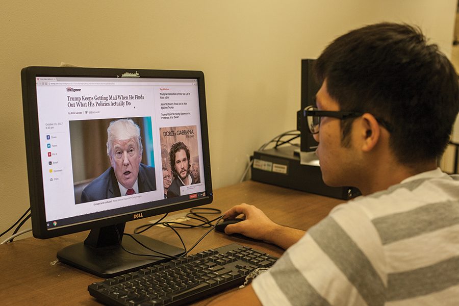 International student Yunjun Yang reads an article about President Donald Trump