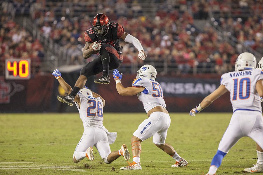 Senior running back Rashaad Penny leaps over Boise State defenders during the Aztecs 31-14 loss on Saturday, Oct.14, at SDCCU Stadium. 