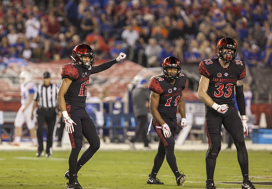 Ron Smith (17), Tariq Thompson (14), and Parker Baldwin (73) celebrate a defensive stop in their game against Boise State on Oct. 14 at SDCCU Stadium. The Aztecs lost the game 31-14.