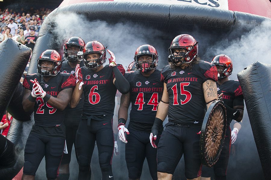 Sophomore+running+back+Juwan+Washington%2C+senior+wide+receiver+Mikah+Holder%2C+sophomore+linebacker+Kyavha+Tezino+and+senior+fullback+Nick+Bawden+lead+SDSU+onto+the+field+before+its+opening+game+win+over+UC+Davis+Sept.+2.