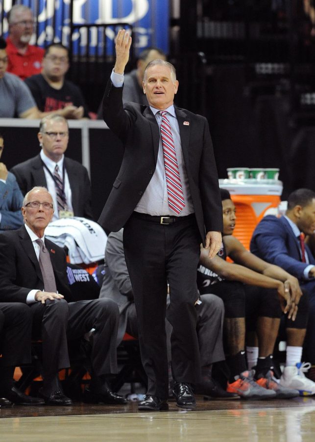 SDSU head coach Brian Dutcher walks the sidelines during the 2016-17 season as Steve Fisher looks on. 