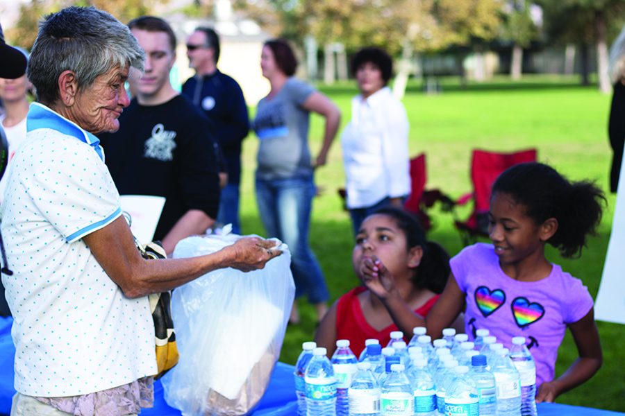 Kathy Cline accepts food and water from a food-sharing event in El Cajons Wells Park.