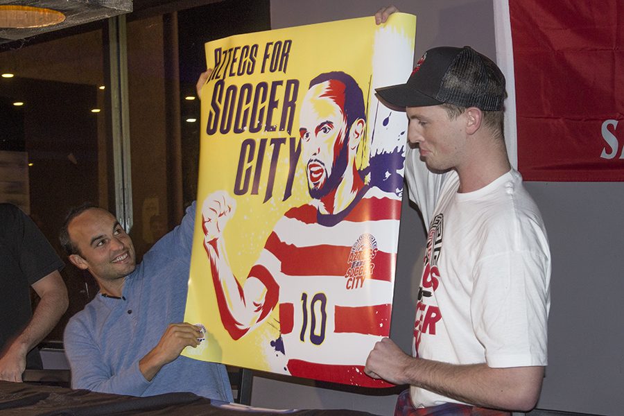 Retired+professional+soccer+player+Landon+Donovan+and+graphic+design+sophomore+Chandler+Brunelli+hold+up+a+poster+promoting+Aztecs+for+SoccerCity.