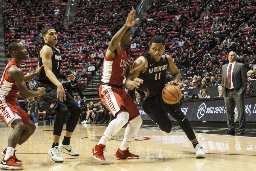 Matt Mitchell drives around UNLV's Jovan Mooring during the Aztecs 94-56 victory on Feb. 17 at Viejas Arena. 