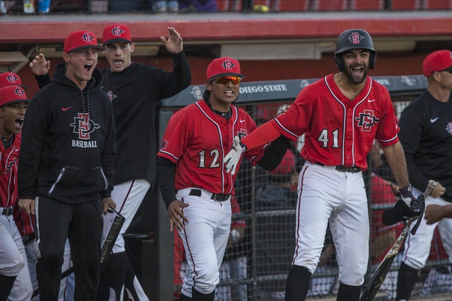 SDSU players celebrated outside the dugout amidst a four-run eighth inning during the Aztecs 5-4 win over Grand Canyon on Feb. 25 at Tony Gwynn Stadium. 