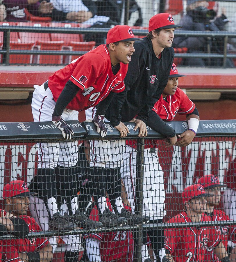 Freshman outfielder Sean Ross and junior pitcher Garrett Hill hang over the dugout railing during the Aztecs 5-4 win over Grand Canyon on Feb. 25 at Tony Gwynn Stadium. 