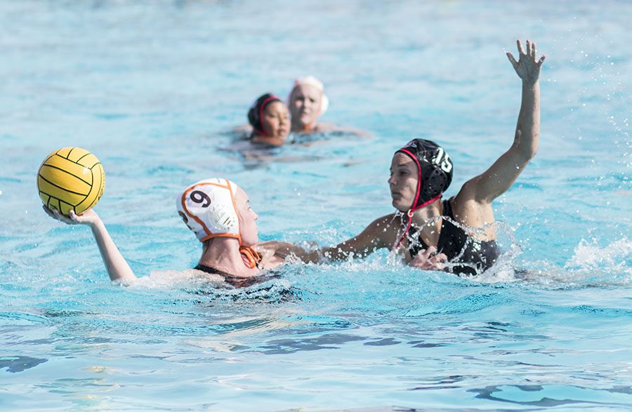 Princeton freshman attacker Kailie McGeoy holds up the ball as senior driver Katrina King defends during the Aztecs 10-4 loss at the Aztec Aquaplex on March 19.