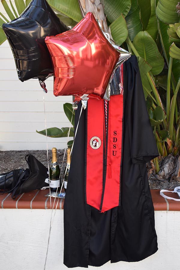 Champagne, confetti, balloons and a graduation gown near Hepner Hall.