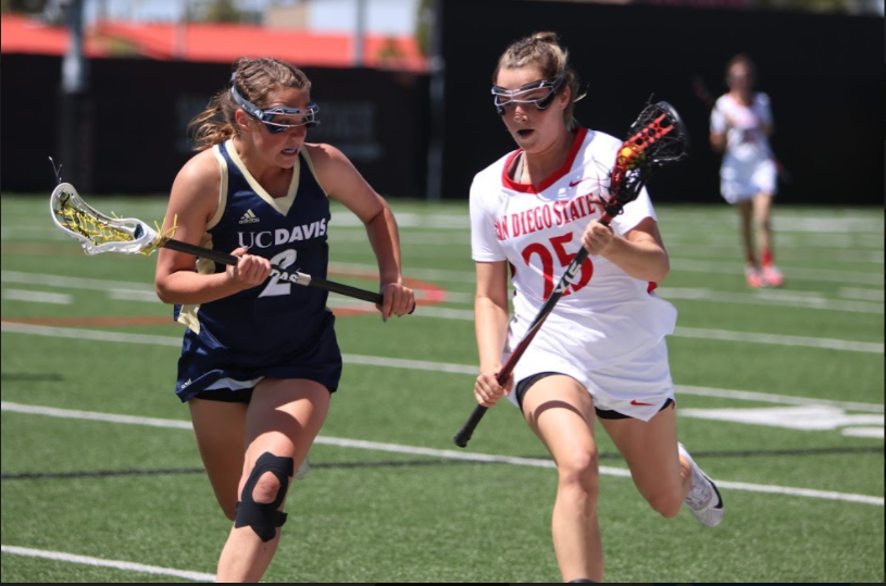 SDSU sophomore defender Sarah McDonagh (25) is chased by UC Davis sophomore attacker Amanda Outcalt (2) during the Aztecs 15-9 defeat to the Aggies at the Aztec Lacrosse Field on April 8. 