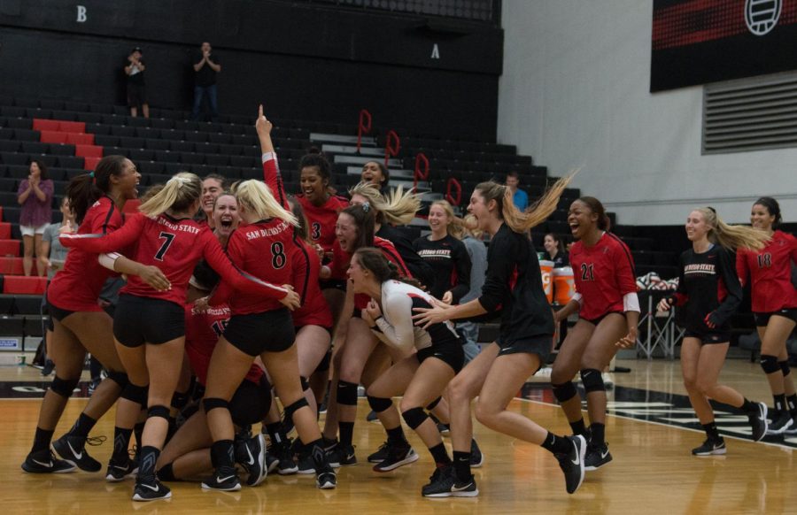 The Aztecs storm the court after defeating Wyoming in five sets on Sept. 29 at Peterson Gym. The win snapped a 13-game losing streak for SDSU. 
