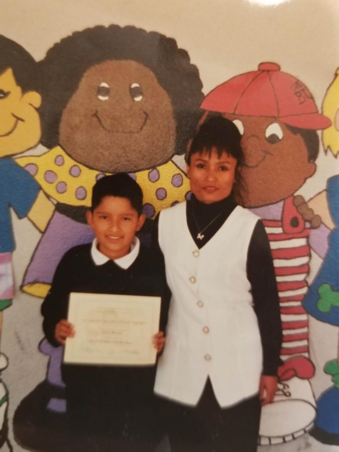 Antonio Márquez, junto con su mamá, recibe un diploma en la primaria.