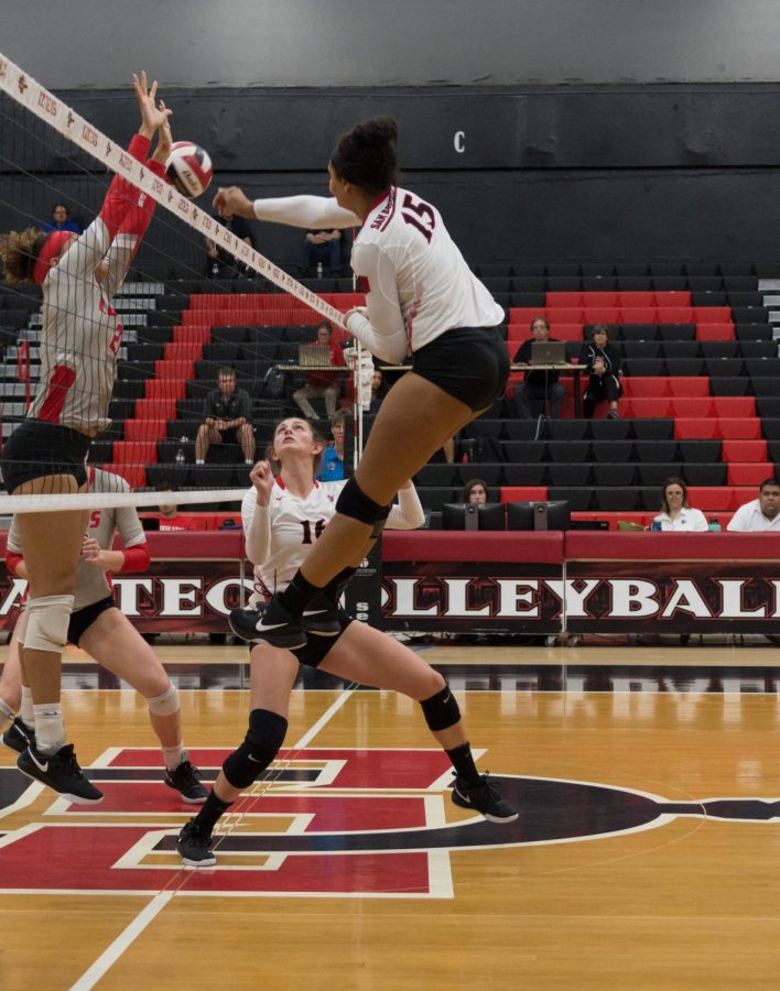 Senior middle blocker Deja Harris spikes the ball over New Mexico defenders during the Aztecs four-set victory on Oct. 11 at Peterson Gym.