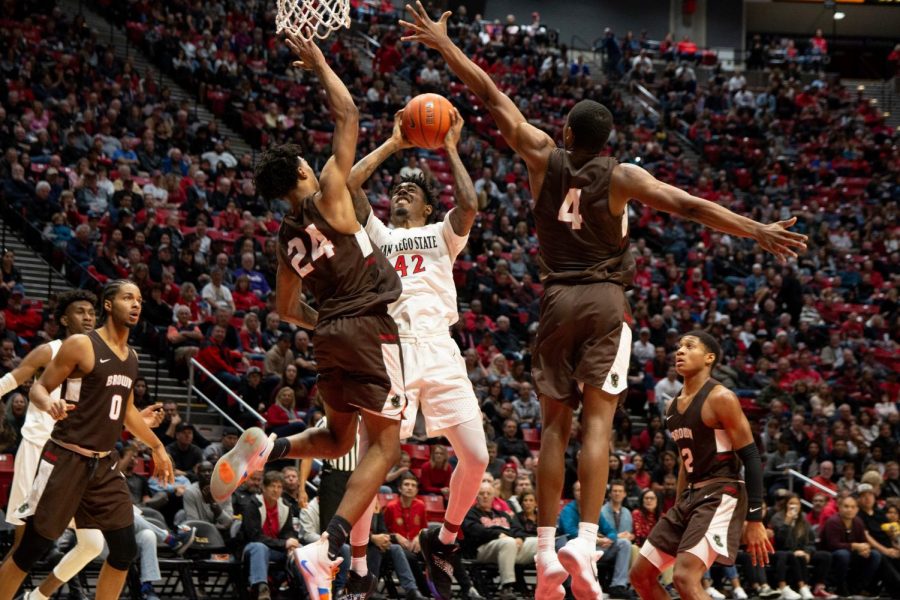 Senior guard Jeremy Hemsley attempts a shot against two Brown defenders during the Aztecs 82-61 loss against the Bears on Dec. 29 at Viejas Arena.