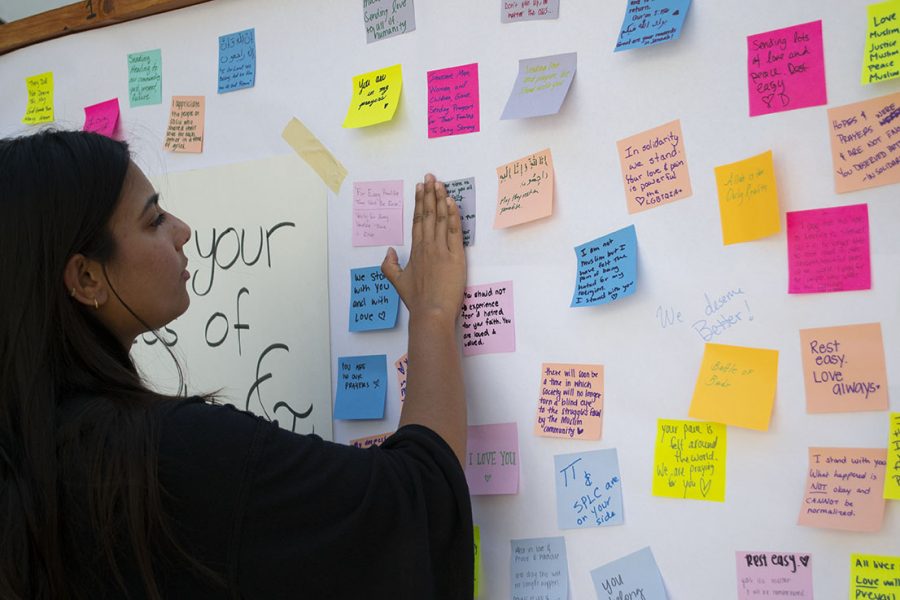 A student placed  post-it with words of support on a wooden board in the student union on March 25.