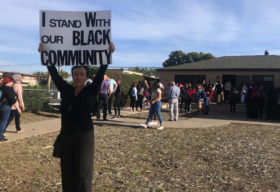 Dania Brett, University Senate Administrative Analyst, holds a sign that says I stand with our black community outside the Black Resource Center on the afternoon of April 15, 2019. 