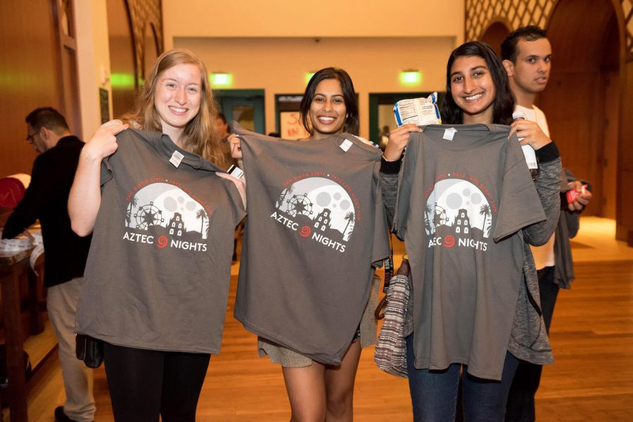 Three+students+get+free+shirts+in+Montezuma+Hall+during+one+of+the+Aztec+Nights+events+in+2017.+This+year+Aztec+Nights+events+will+also+give+away+free+items+and+food+on+campus.