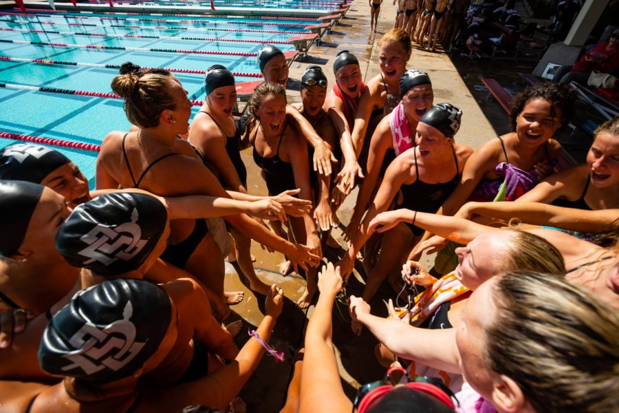 The SDSU Swim & Dive team huddles amidst competition during the 2018-19 season at the Aztec Aquaplex.