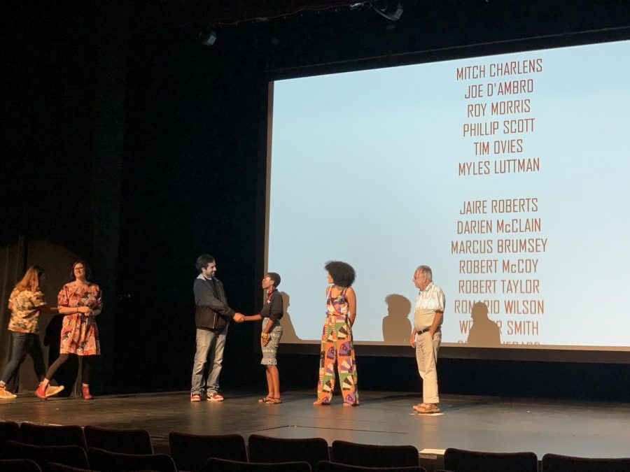 David Pradel, on the left, shakes hands with the co-creator of the documentary in the film festival called Mis(s) Interpreted during the credits.