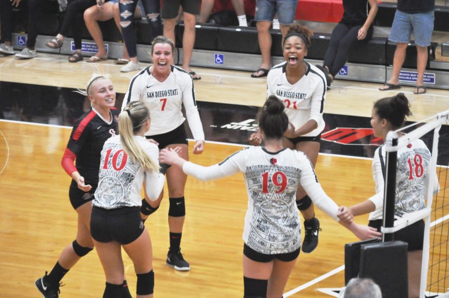 Senior outside hitter Hannah Turnlund (7) and sophomore outside hitter (21) celebrate an Aztec point during the Aztecs 3-2 comeback victory over West Virginia on Sept. 6 at Peterson Gym.