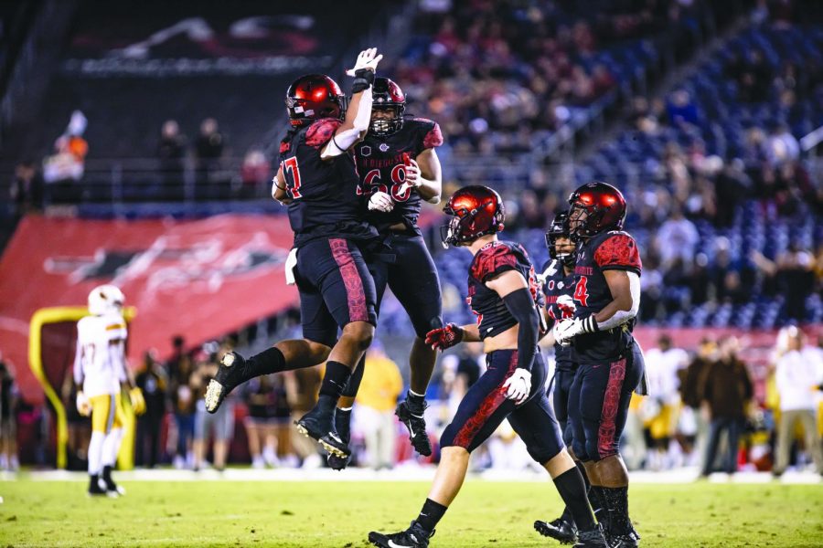 Sophomore defensive lineman Keshawn Banks (left) and senior defensive lineman Myles Cheatum (right) celebrate in the air during the Aztecs’ 26-22 win against Wyoming on Oct. 12 at SDCCU Stadium.