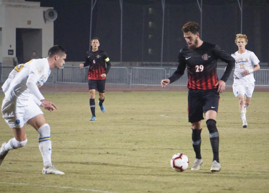 Senior midfielder Adam Vargas attempts to get past a UCLA defender in the Aztecs’ 1-0 loss to the Bruins on Nov. 16 at the SDSU Sports Deck.