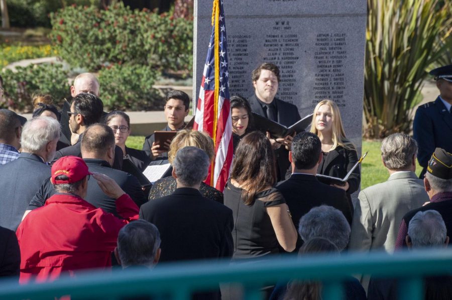 SDSU alumnus and Vietname veteran, Gilbert Harrison salutes the flag during the SDSU Chamber Choirs performance of the national anthem. 