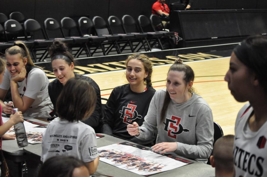 Members of the Aztecs womens basketball team  sign autographs following their matchup against Air Force on Saturday.