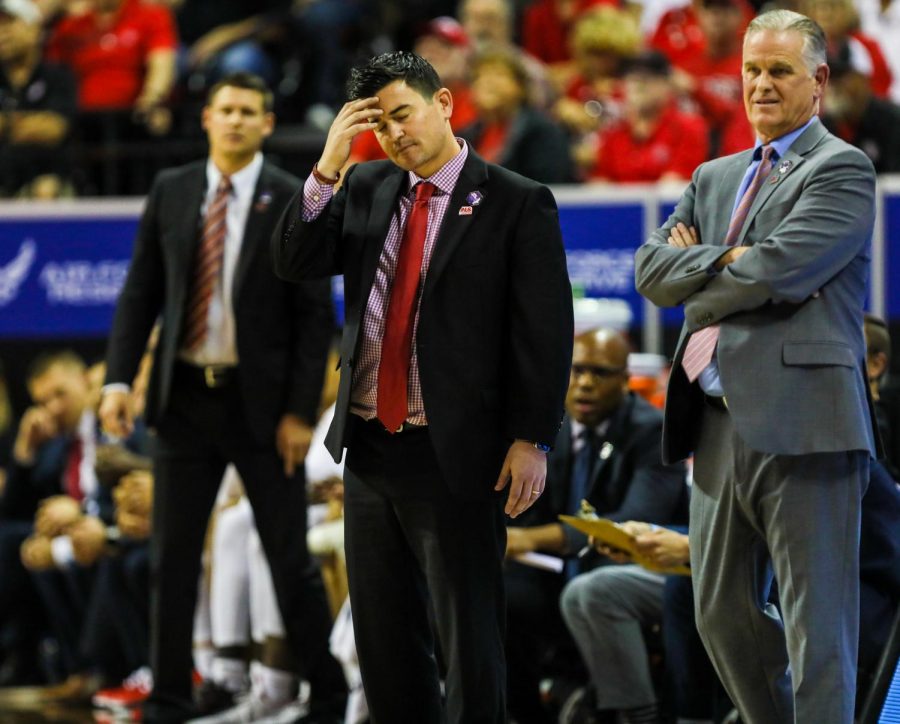 Aztecs assistant coach David Velasquez (middle) puts his head down in disappointment during the Aztecs 59-56 loss to Utah State on March 11 at the Thomas and Mack Center. 