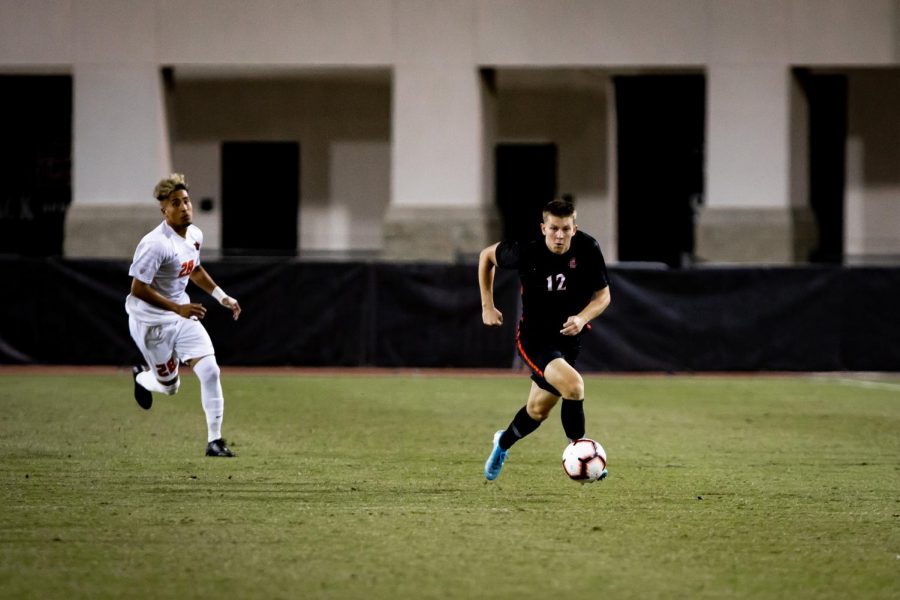 Then-freshman forward Hunter George dribbles the ball while being pursued by an Oregon State player during the Aztecs 1-0 overtime loss to the Beavers on Oct. 24, 2019 at the SDSU Sports Deck.