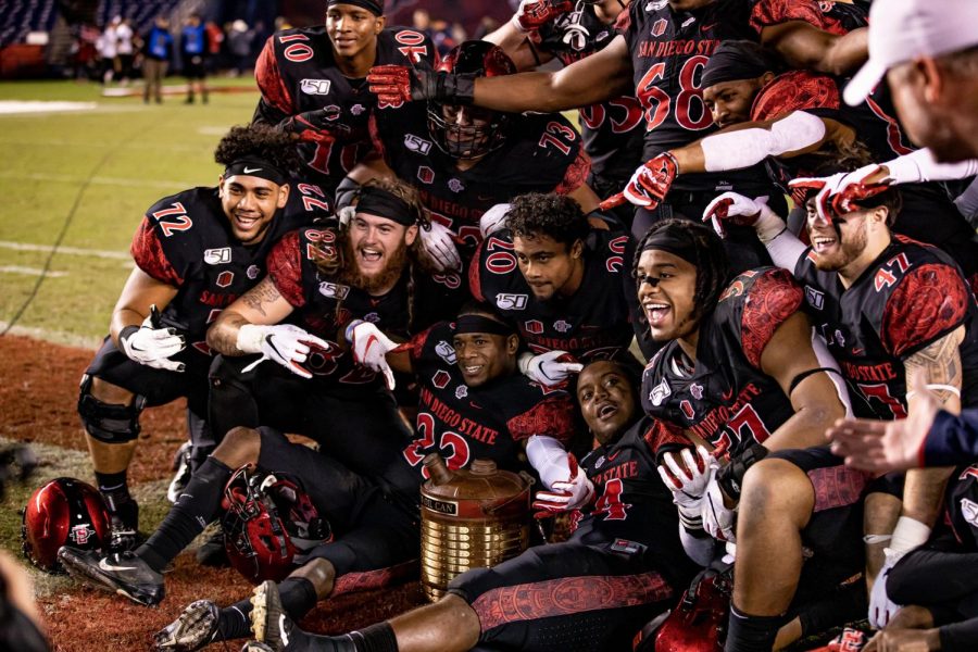Members of the 2019 SDSU football team pose in celebration with the Old Oil Can trophy after the Aztecs’ 17-7 victory over Fresno State on Nov. 15, 2019 at SDCCU Stadium. The win over the Bulldogs marked the first time the Old Oil Can was in SDSUs possession since 2016.