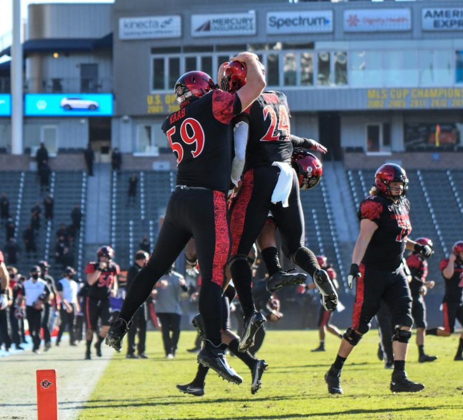 Senior+linebacker+Segun+Olubi+%28right%29+celebrates+with+junior+long+snapper+Jacob+Raab+after+Olubi+returned+an+interception+for+a+touchdown+during+the+Aztecs+34-10+win+over+Hawaii+on+Nov.+14+at+Dignity+Health+Sports+Park.