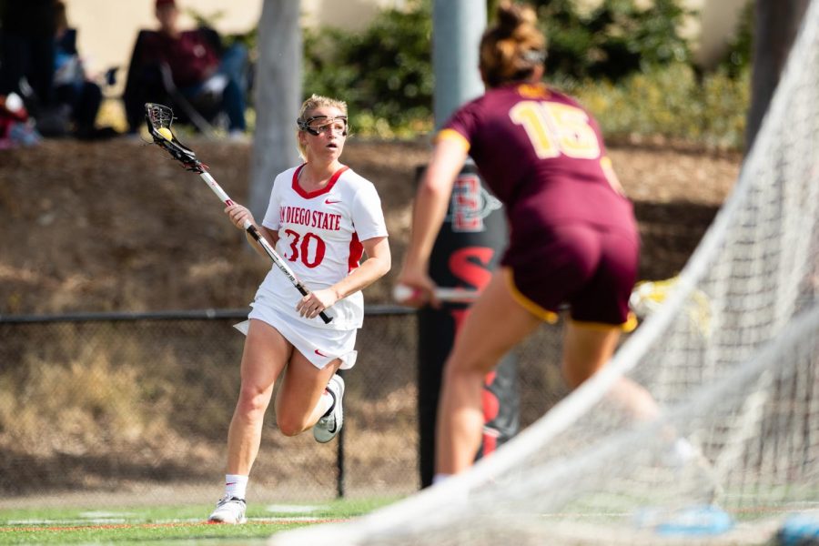 San Diego State then-junior midfielder Bailey Brown carries the ball upfield during the Aztecs' 19-18 win over Arizona State on Feb. 20, 2020 at Aztec Lacrosse Field.